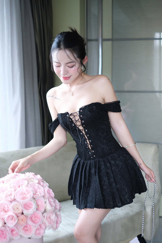 Woman in a black dress holding pink flowers indoors