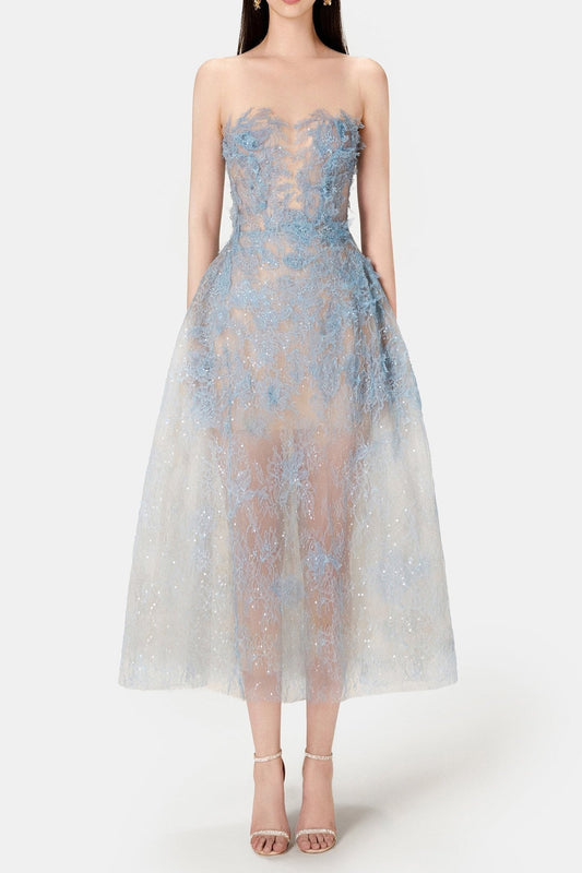 A model wearing a blue beaded lace mini dress with a fitted bodice and flowing skirt, standing against a white background.