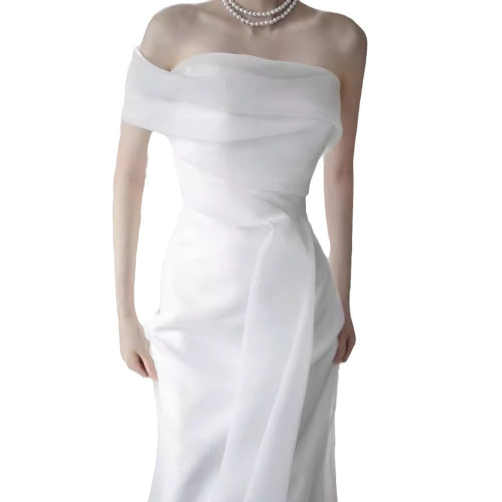Lisa in a simple yet elegant white French-style one-shoulder mermaid Maxi Dress