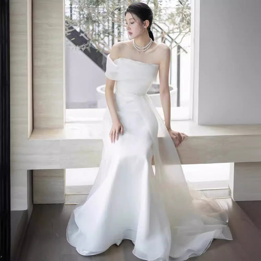 Lisa in a simple yet elegant white French-style one-shoulder mermaid Maxi Dress