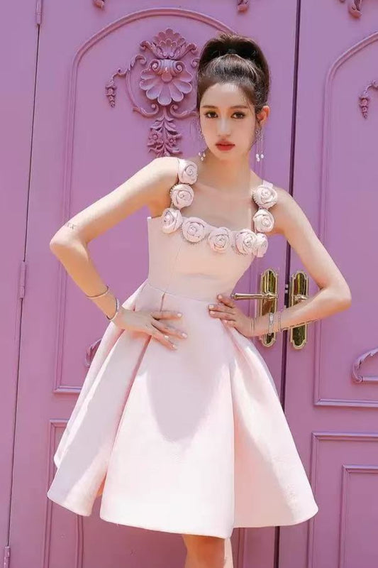 Woman in a pink dress standing in front of a decorative purple door