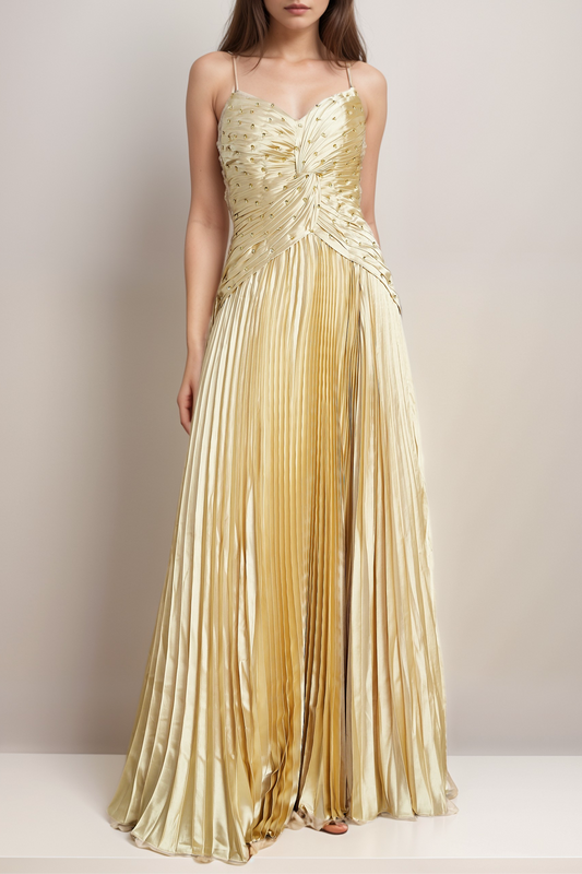 A model wearing a gold, V-neck, bustier style, sleeveless, spaghetti straps, fully pleated maxi dress embellished with gold sequins.