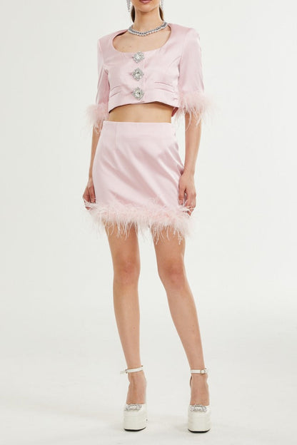 Person wearing a pink outfit with feathered details on a white background