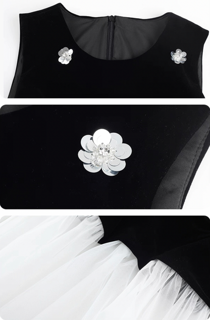 Black top with floral embellishments and white skirt