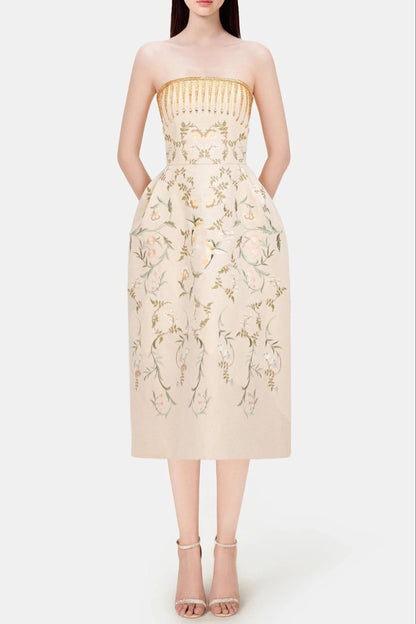 Beige strapless dress with floral embroidery on a white background