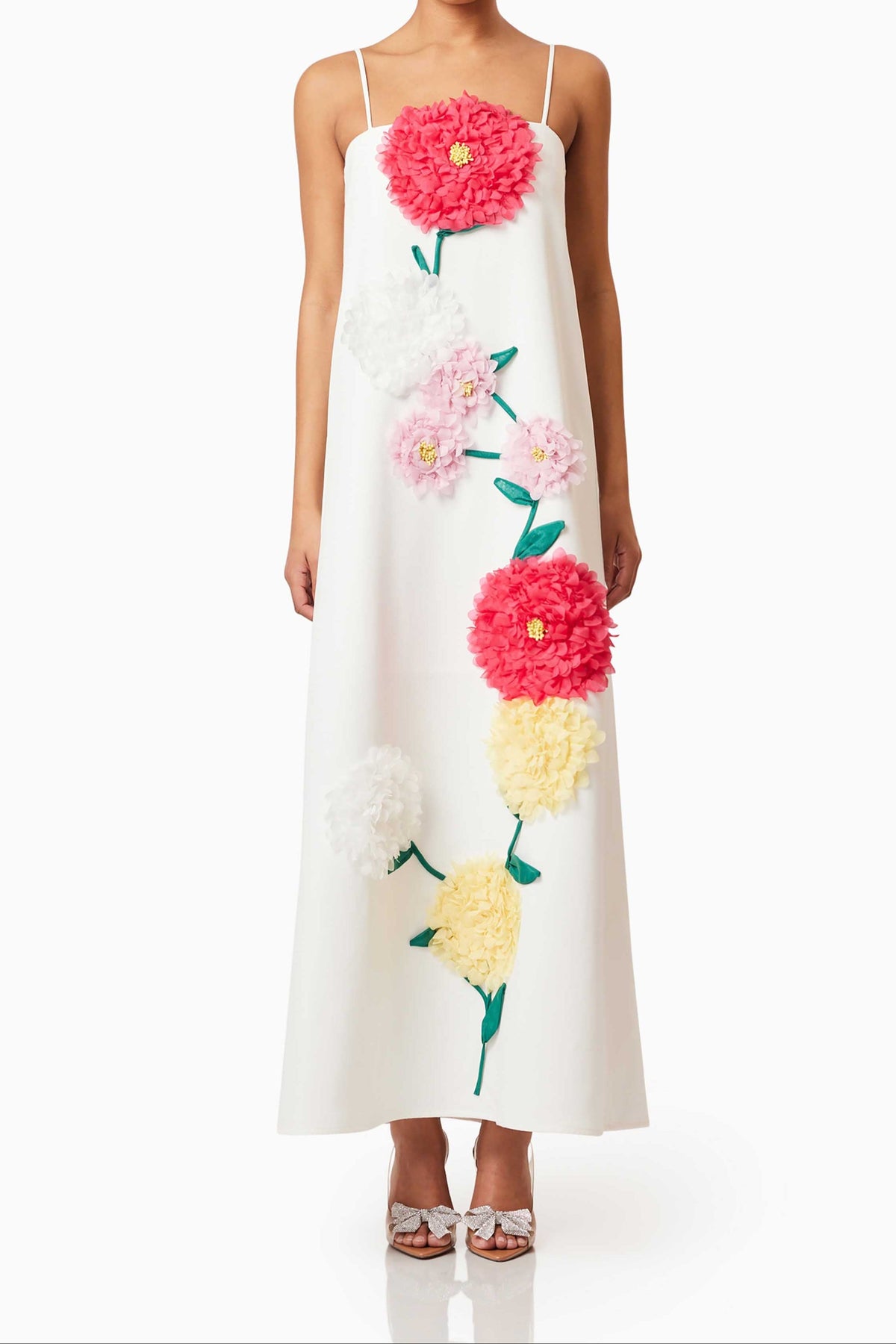 A white maxi dress with vibrant, multicolored 3D floral embroidery, featuring adjustable spaghetti straps and a center back zipper.