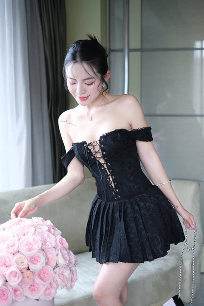 Woman in a black dress holding pink flowers indoors