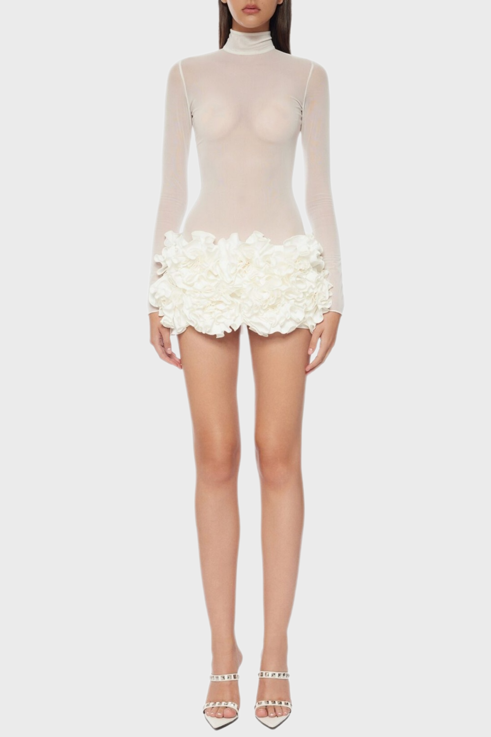 A white floral mesh long sleeve mini dress with a sheer neckline and white platform heels.