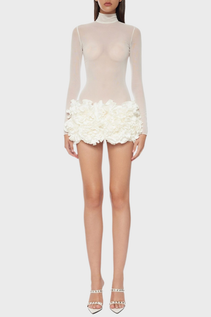 A white floral mesh long sleeve mini dress with a sheer neckline and white platform heels.