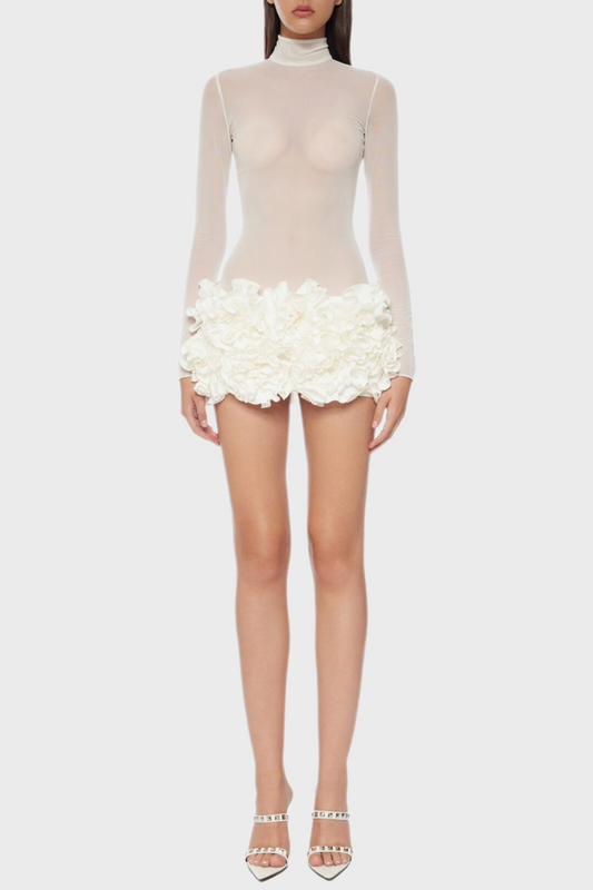 A white floral mesh long sleeve mini dress with a sheer neckline and white platform heels.