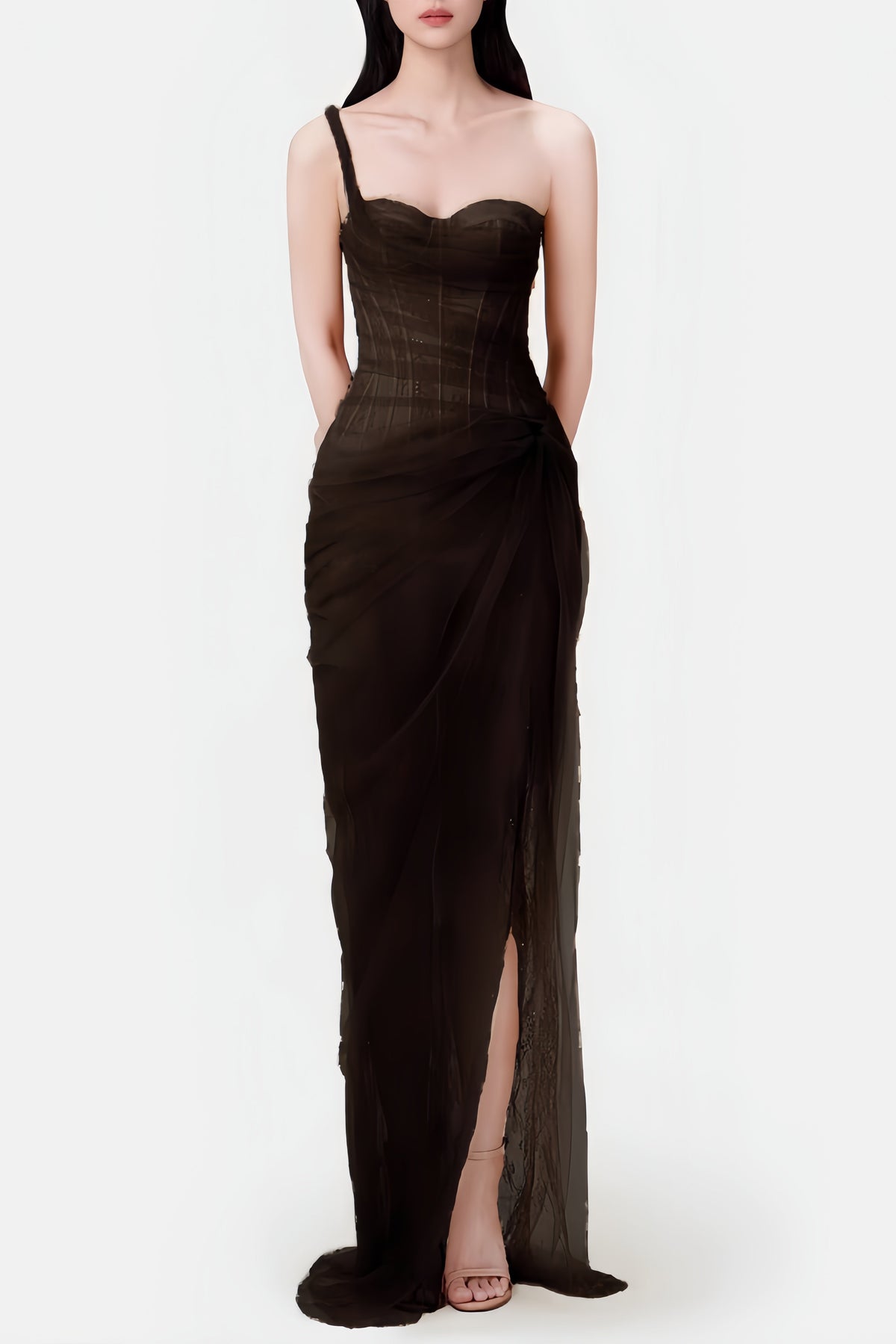 Woman wearing a black evening gown with a slit on a white background