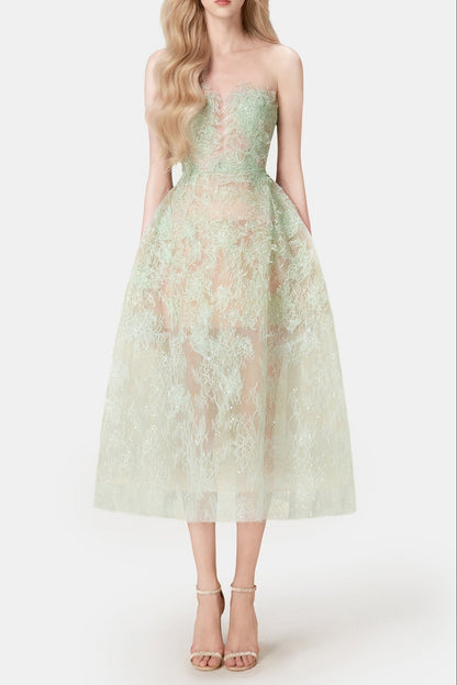 A model wearing an elegant mint beaded lace midi dress with a fitted bodice and flowing skirt, paired with heels.