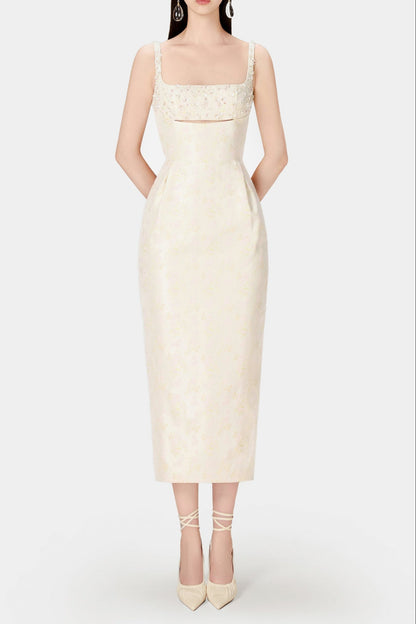 A model wearing an ivory beaded brocade pencil midi dress with a fitted silhouette and sleeveless design, paired with white platform heels.