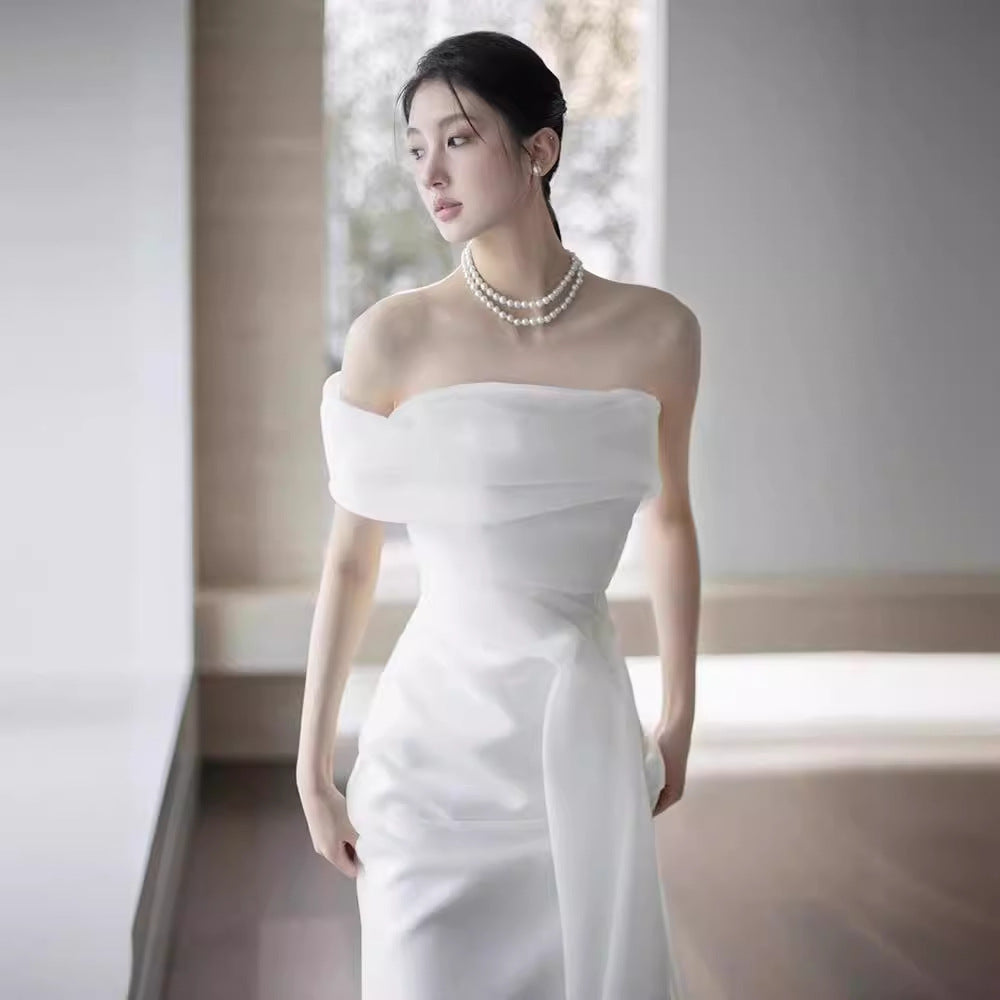 Lisa in a simple yet elegant white French-style one-shoulder mermaid Maxi Dress