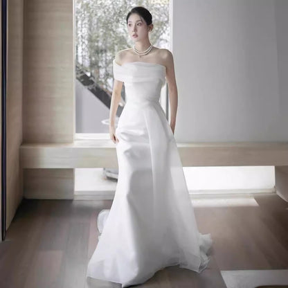 Lisa in a simple yet elegant white French-style one-shoulder mermaid Maxi Dress