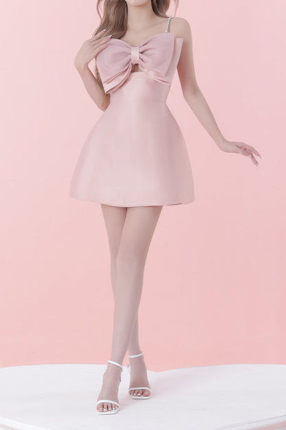 Pink dress with a large bow detail on a pink background